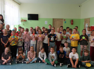 Uczniowie klas 1-3, ubrani w kropki, pozują do zdjęcia na korytarzu.