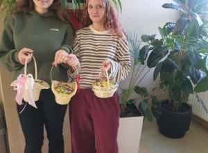 Przewodnicząca Marta Tkaczyk wraz z Zastępczynią Ingą Kobacką trzymają słodki poczęstunek dla chłopców.