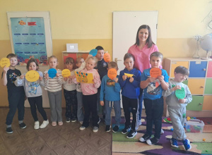 Uczniowie klasy I z pedagogiem specjalnym prezentują balony z pozytywnymi słowami.