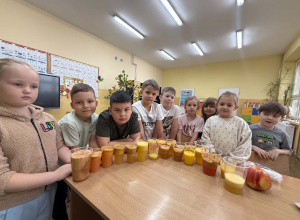 Dzieci z klasy pierwszej pokazują, ile soku wycisnęły z owoców.