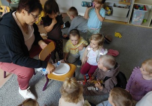 Dzieci z grupy „Zielone Żabki” obserwują doświadczenie z wodą i pieprzem.