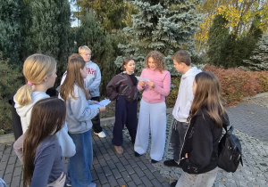 Uczennica czyta tekst o historii książki, który dotyczy powstania i występowania glinianych tabliczek.