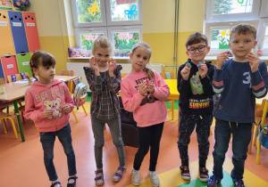 Przedszkolaki trzymają w ręku słodki upominek.