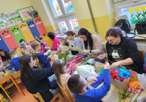 Filip, Marysia, Staś i Kasia wspólnie z rodzicami wykonują palmę.