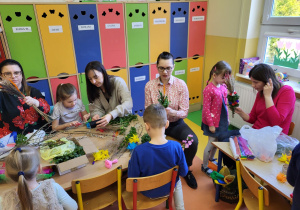 Marysia, Franek, Zosia i Kasia wykonują kwiaty do palmy wielkanocnej.