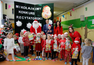 Wspólne zdjęcie przedszkolaków z grupy Misie ze MIKOŁAJEM z panią dyrektor, panem wójtem oraz z wychowawcą. Śpiewanie piosenki dla Mikołaja