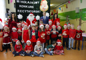 Wspólne zdjęcie przedszkolaków z grupy Pszczółki ze MIKOŁAJEM z panią dyrektor, panem wójtem oraz z wychowawcą. Śpiewanie piosenki dla Mikołaja.