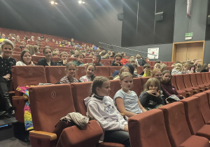 Uśmiechnięci uczniowie oczekują na seans.