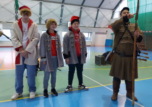 trzech uczniów i artysta z grupy Rekonstrukto prezentują stroje z okresu powstania