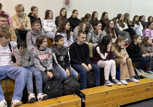 uczniowie z klas 4 – 8 siedzą na trybunach podczas oglądania występów