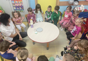 Dzieci dotykają palcem umoczonym w mydełku mleka oprószonego pieprzem.