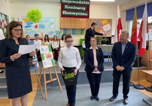 zdjęcie, na którym widzimy panią wizytator, pana przewodniczącego, panią dyrektor szkoły nr 64 oraz grupę uczniów, którzy przedstawiali program słowno – muzyczny na temat Żołnierzy Wyklętych.