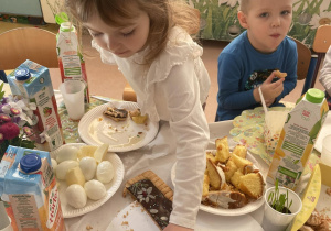 Dziewczynka sięga po kawałek mazurka.