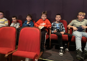 Uśmiechnięci uczniowie klas IV oczekują na spektakl pn. ,,Akademia Pana Kleksa”.