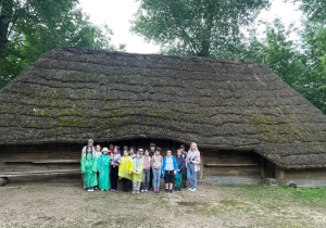 opiekunowie i klasa 4 przed chatą w Biskupinie