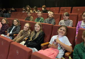grupa uczniów w kinie oczekuje na projekcję filmu