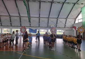 Dzieci stoją w grupach podczas otwarcia Olimpiady