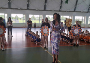 Przemawia Dyrektor szkoły, w tle siedzące dzieci