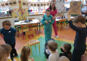 Chłopiec z grupy Krasnale w fartuchu pielęgniarskim.