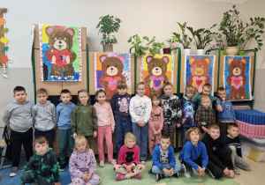 Uczniowie klasy pierwszej przedstawiają grupowe prace plastyczne.