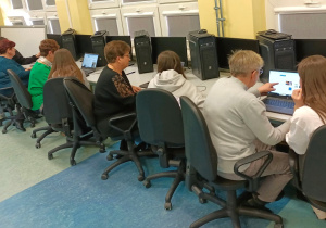 Stanowiska komputerowe, przy których siedzą uczestnicy zajęć, przeglądają w internecie interesujące ich strony.
