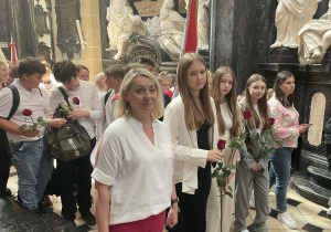 Grupa uczniów wraz z opiekunem podczas procesji przed ołtarz z czarnym krucyfiksem, przed którym modliła się Królowa Jadwiga.