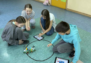 Uczniowie obserwują starcie swoich robotów.