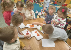 Dzieci z grupy Słoneczka nakładają kawałki warzyw na patyczek.