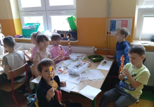 Dzieci z grupy Skoczki przy stoliku prezentują owocowe szaszłyki.
