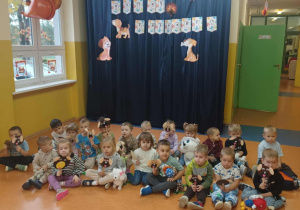 Zdjęcie grupowe dzieci z grupy Kamyczki w Dniu Kundelka na korytarzu przedszkolnym.