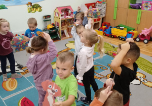Dzieci z grupy Kamyczki w trakcie zabawy ruchowej z pieskami.