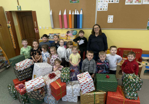 Grupa Żabki z zapakowanymi i udekorowanymi kokardami prezentami.