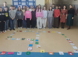 Uczniowie klasy 6 oraz Pani Marta Skoneczny i Pani Marta Płocka stoją za liczbą 50 ułożoną na podłodze z otrzymanych kartek świątecznych.
