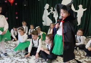 Dwie dziewczynki przebrane za czarownice na miotle.