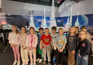 Grupa dzieci przed słynnymi budowlami z klocków Lego.