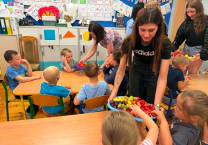 Samorząd Uczniowski rozdaje owoce dzieciom.