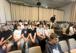 Uczniowie klas 8 siedzący na widowni.