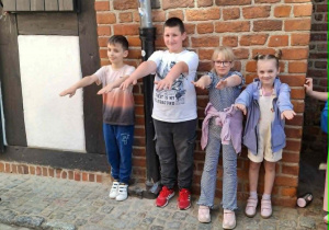 Uczniowie próbują stać pod Krzywą Wieżą.