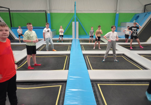 zdjęcie ukazuje grupkę skaczących na osobnych trampolinach dzieci