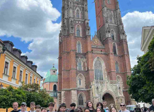 Uczniowie klasy szóstej pozują do wspólnego zdjęcia przed gotycką Katedrą św. Jana Chrzciciela na wrocławskim Ostrowie Tumskim, uśmiechnięci i gotowi na dalsze przygody.