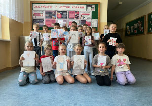 Uczniowie z portretami swoich mam.