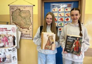 Uczennice naszej szkoły, Ania i Julia z nagrodami książkowymi i dyplomami, za otrzymane wyróżnienia w konkursie.
