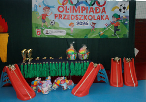 Olimpiada Przedszkolaka - stoisko z pucharami, medali i nagrodami rzeczowymi.