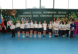 Uczniowie klasy III b wraz z Panią Dyrektor zaproszonymi Gośćmi oraz wychowawcą Mariolą Kraszewską i Panią Patrycją Sułek, prezentują otrzymane książki i świadectwa.