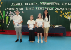 Pani Dyrektor w raz z uczniami którzy osiągnęli w roku Szkolnym 2025/ 2026 100% frekwencję i prezentują otrzymane dyplomy.