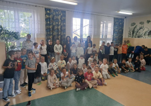 Uczniowie klas 1 – 3 wraz z Panią Dyrektor i nauczycielami stoją na korytarzu prezentują swoje ubrania w kropki.