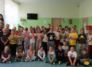 Uczniowie klas 1-3, ubrani w kropki, pozują do zdjęcia na korytarzu.
