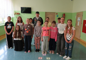 Uczniowie klas 4-6, ubrani w kropki, pozują do zdjęcia na korytarzu.