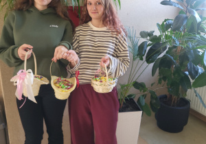 Przewodnicząca Marta Tkaczyk wraz z Zastępczynią Ingą Kobacką trzymają słodki poczęstunek dla chłopców.