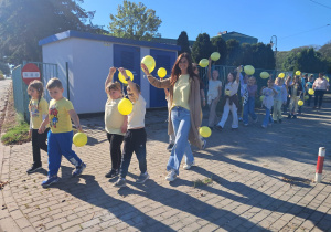 Psycholog szkolny wraz z uczniami podczas przemarszu.